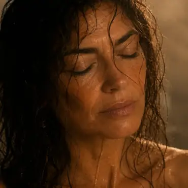 Isabel en la ducha con el agua caliente cayendo sobre los hombros, el cuerpo presente mientras la mente integra algo que ocurrió días antes — Serie Sexualidad Tántrica - Tántrika™